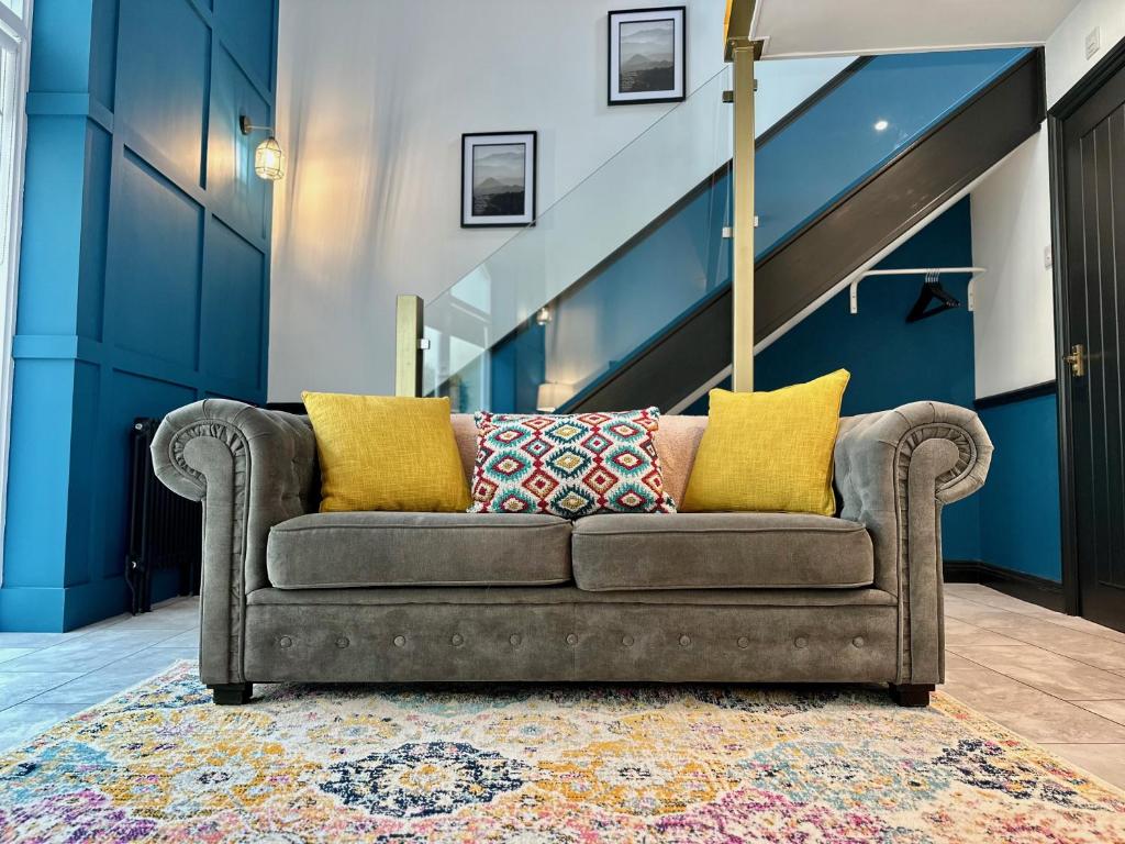 eine Couch auf einem Teppich in einem Zimmer mit einer Treppe in der Unterkunft The Gallery in Blandford Forum