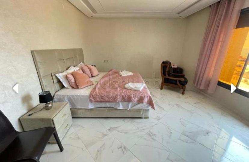 um quarto com uma cama com almofadas cor-de-rosa em Sunny house em Tânger