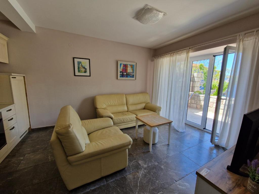 a living room with two chairs and a tv at Kazanegra Exclusive Apartments in Sveti Stefan