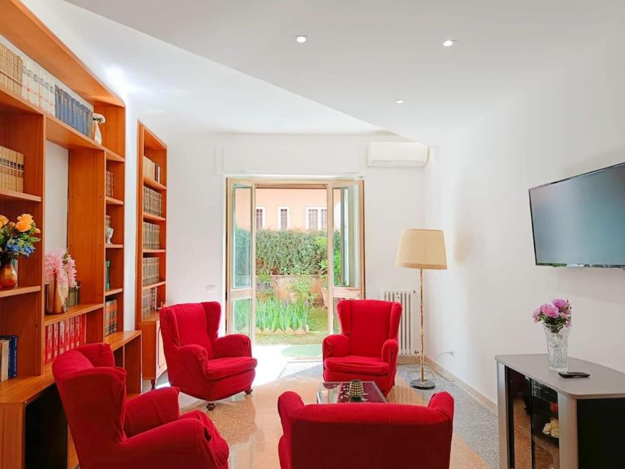 a living room with red chairs and a flat screen tv at [Rome] House with garden near the Olympic Stadium in Rome
