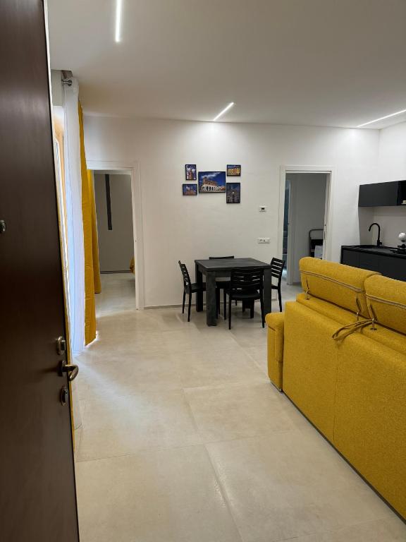 uma sala de estar com um sofá amarelo e uma mesa em Appartamento Umberto em Piacenza