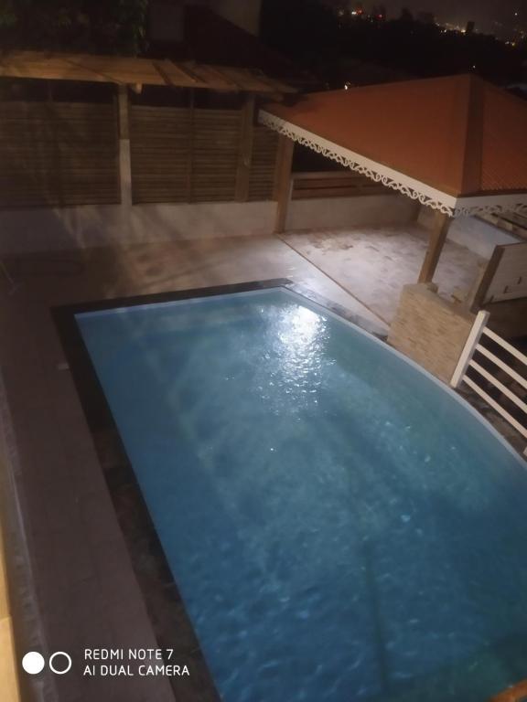 - une vue sur la piscine la nuit dans l'établissement Mon petit coin tranquille, à Saint-Joseph