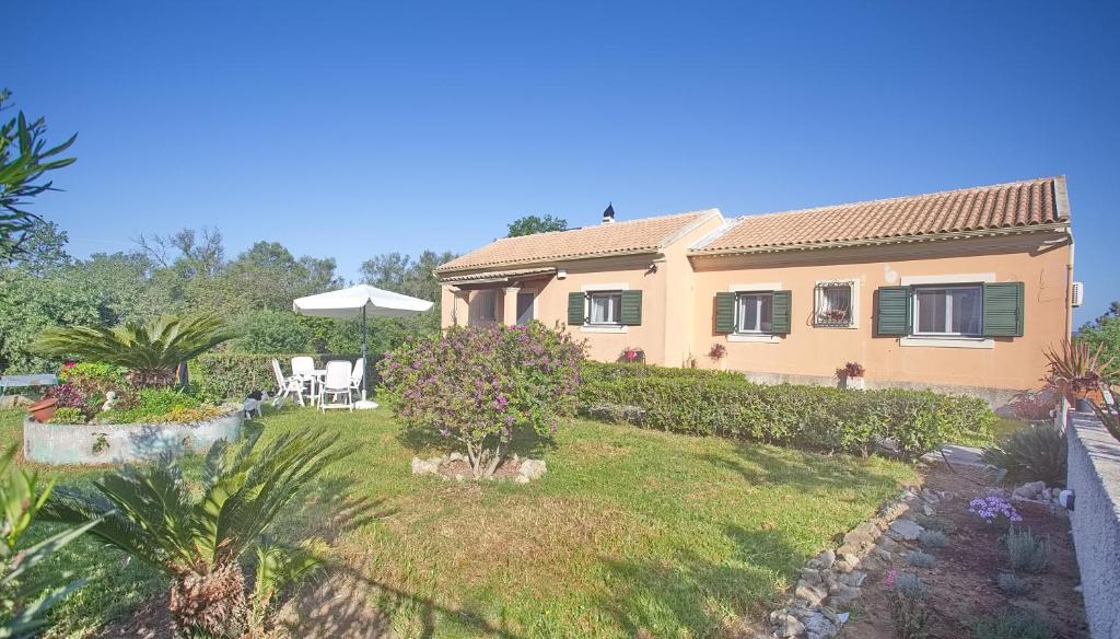 a large house with a yard with a patio at Eleni's House by Corfuescapes in Corfu