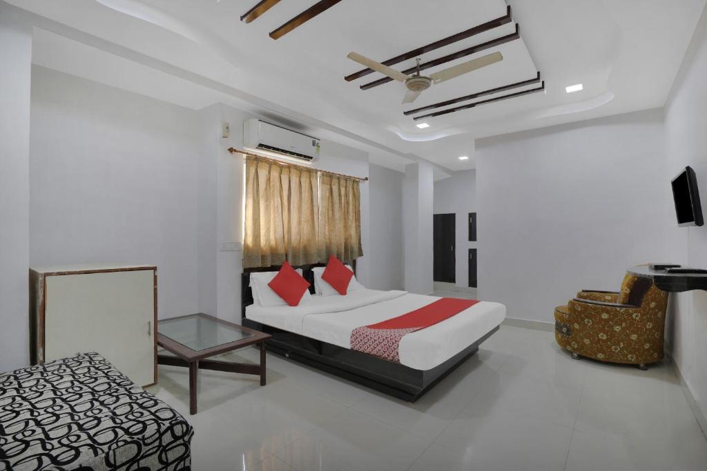 Flagship Hotel Rudra Palace في أحمد آباد: غرفة نوم بسرير وطاولة في غرفة