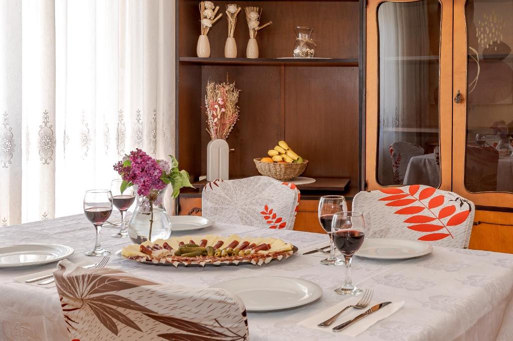 - une table avec une assiette de nourriture et des verres à vin dans l'établissement Apartment Goreta, à Kaštela