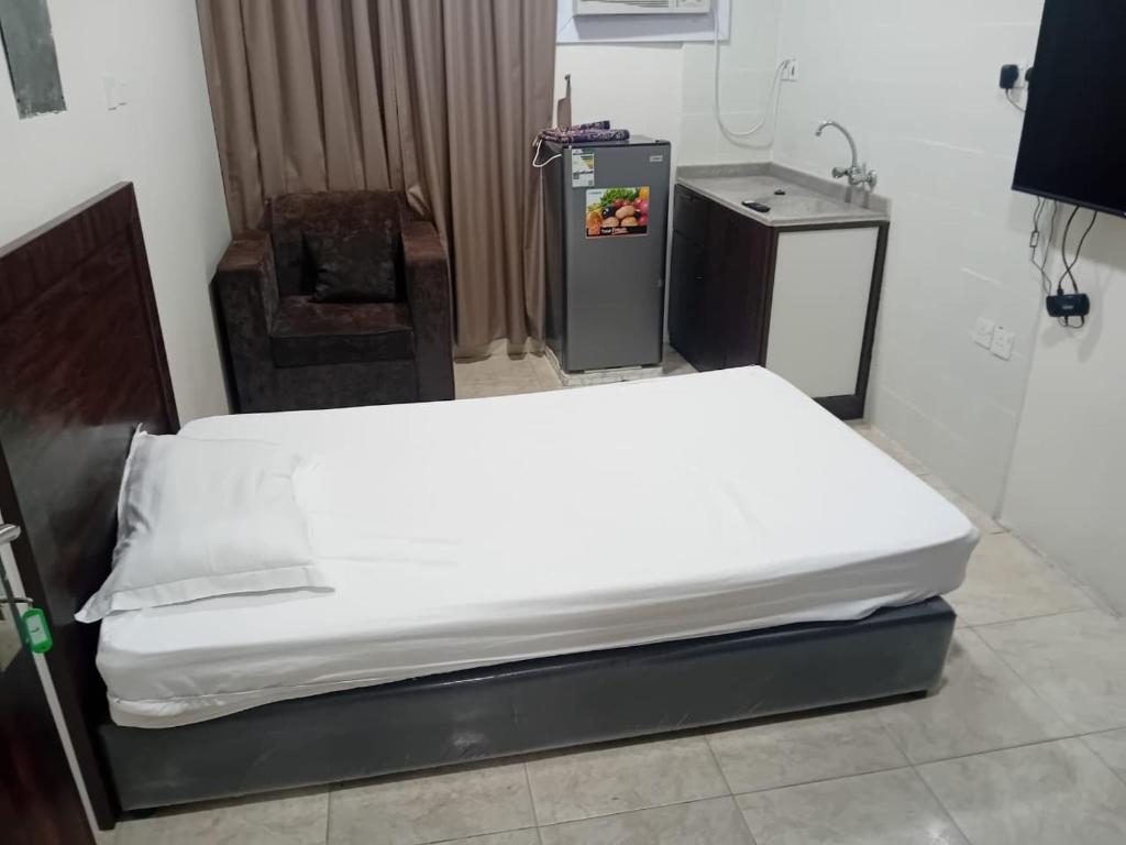 1 dormitorio con 1 cama blanca grande en una habitación en الفاخرة, en Al Khobar