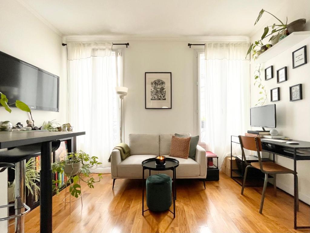 un salon avec un canapé et une table dans l'établissement Charmant 2 pièces lumineux proche métro L14 Clichy proche Paris, à Clichy