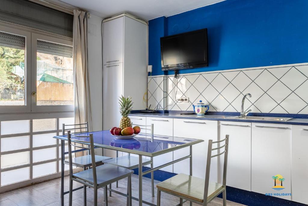 een blauwe en witte keuken met een tafel en stoelen bij Da Paolo Apartment (in front of the beach) in Lloret de Mar