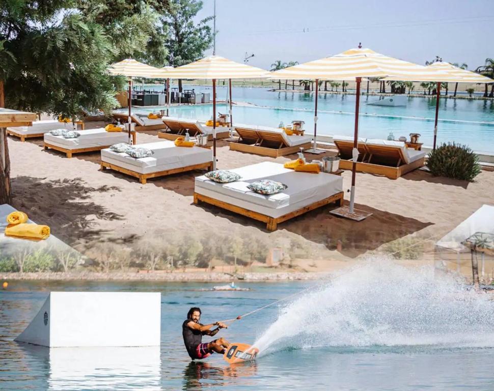 un hombre está en el agua en una tabla de agua en Exquisite Luxury Villa Golf en Marrakech