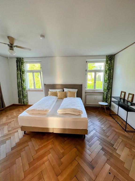 ein großes Schlafzimmer mit einem großen Bett und Holzböden in der Unterkunft Auszeit im Bad Diezlings in Hörbranz