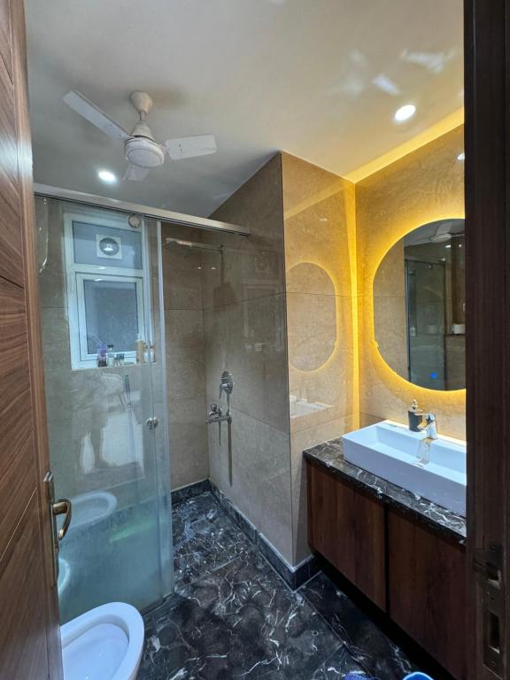 a bathroom with a sink and a shower and a toilet at The LUTF in New Delhi