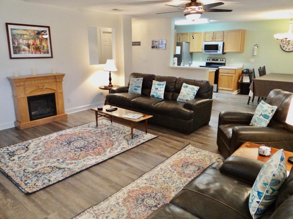 a living room with leather furniture and a fireplace at The Inlet Outlet-Free Park Pass Included in Myrtle Beach