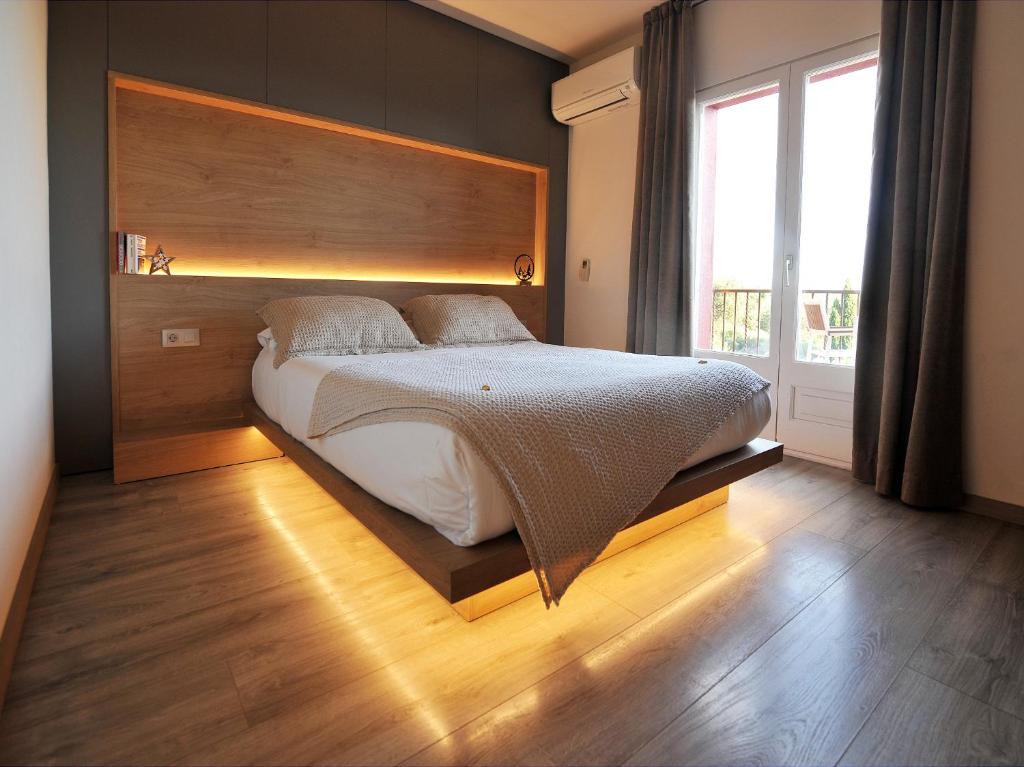 a bedroom with a large bed with a wooden headboard at Hostal Rural Can Pau in Cantallops