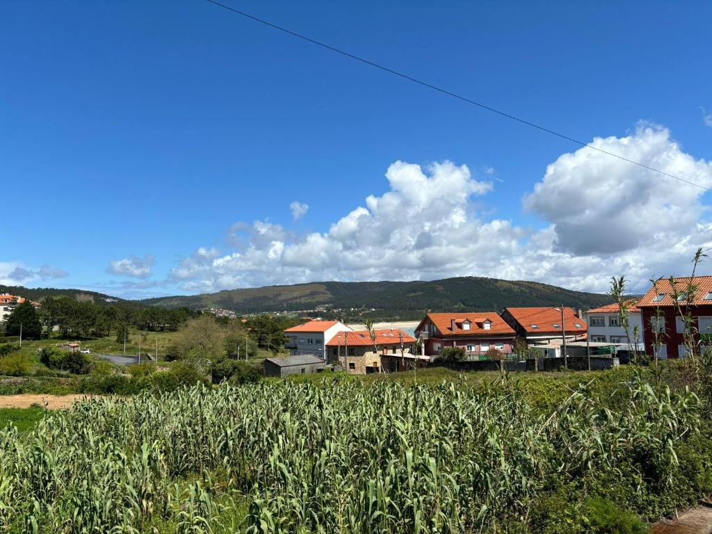 a group of houses with mountains in the background at CASA DE LA NIÑA,Chalet familiar con gran terraza in Fisterra