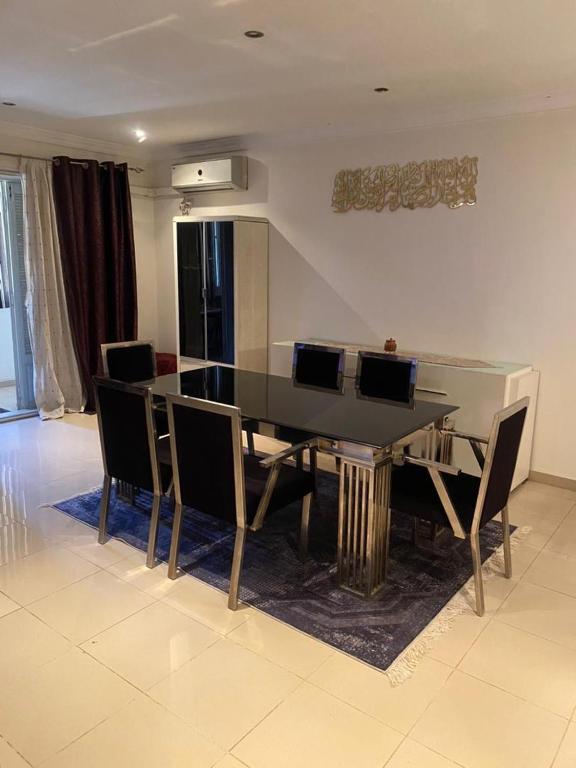 a dining room with a glass table and chairs at Duplex T3 Bien Situé in Annaba