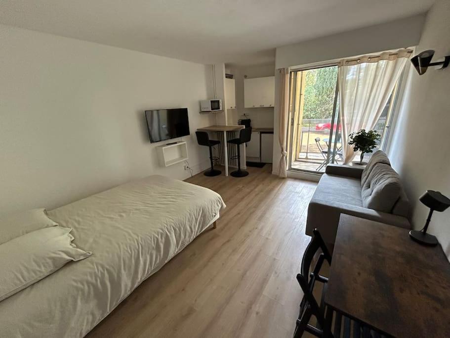 une chambre avec un lit, un canapé et une table dans l'établissement Studio Occitanie-Hopitaux-Facultés & Parking gratuit, à Montpellier