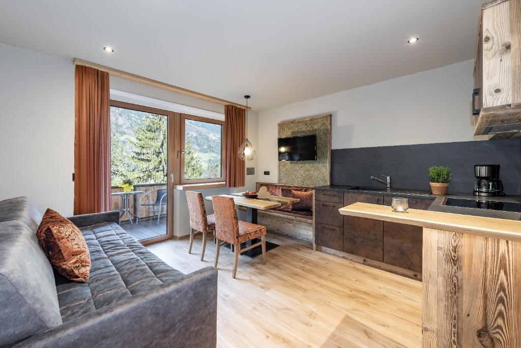 a living room with a couch and a kitchen at Mirabelle Pension Sankt Ursula in Saltusio