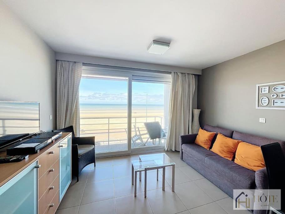 un salon avec un canapé et une vue sur l'océan dans l'établissement Horizon Sérénité Vue Mer, 2e Étage Confort, à Bray-Dunes