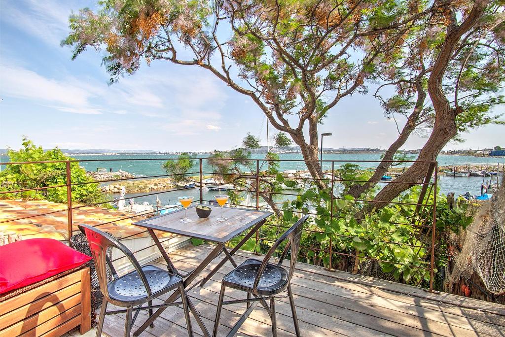 una mesa y sillas en una terraza con vistas al agua en LA CABANE D'ISA, en Sète