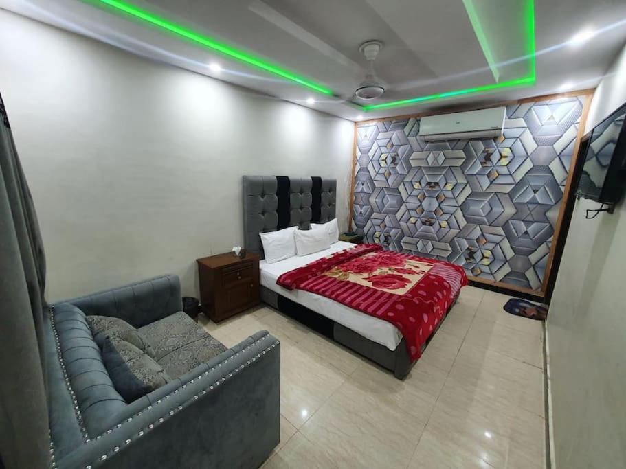 um quarto com uma cama e um sofá num quarto em Stunning Apartment/Guest House em Islamabad