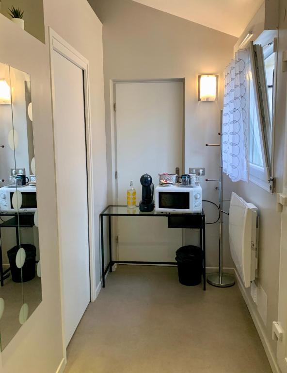 une petite cuisine avec une table et un four micro-ondes dans l'établissement Logement à 2km de la base olympique Vaires sur Marne, à Chelles
