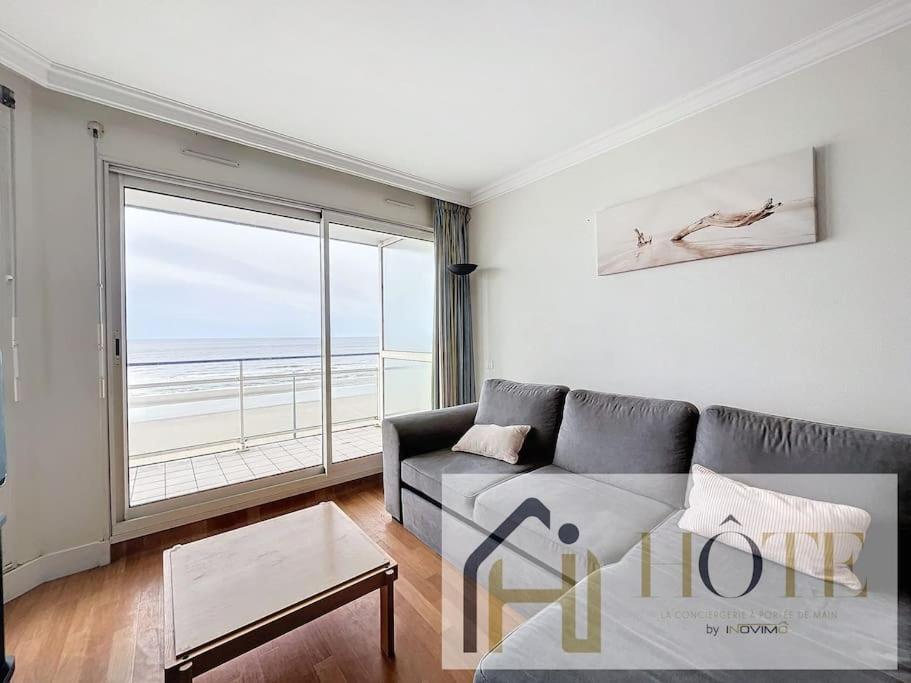 un salon avec un canapé et une grande fenêtre dans l'établissement Horizon Marin - Vue Mer & Confort au 4e Étage, à Bray-Dunes