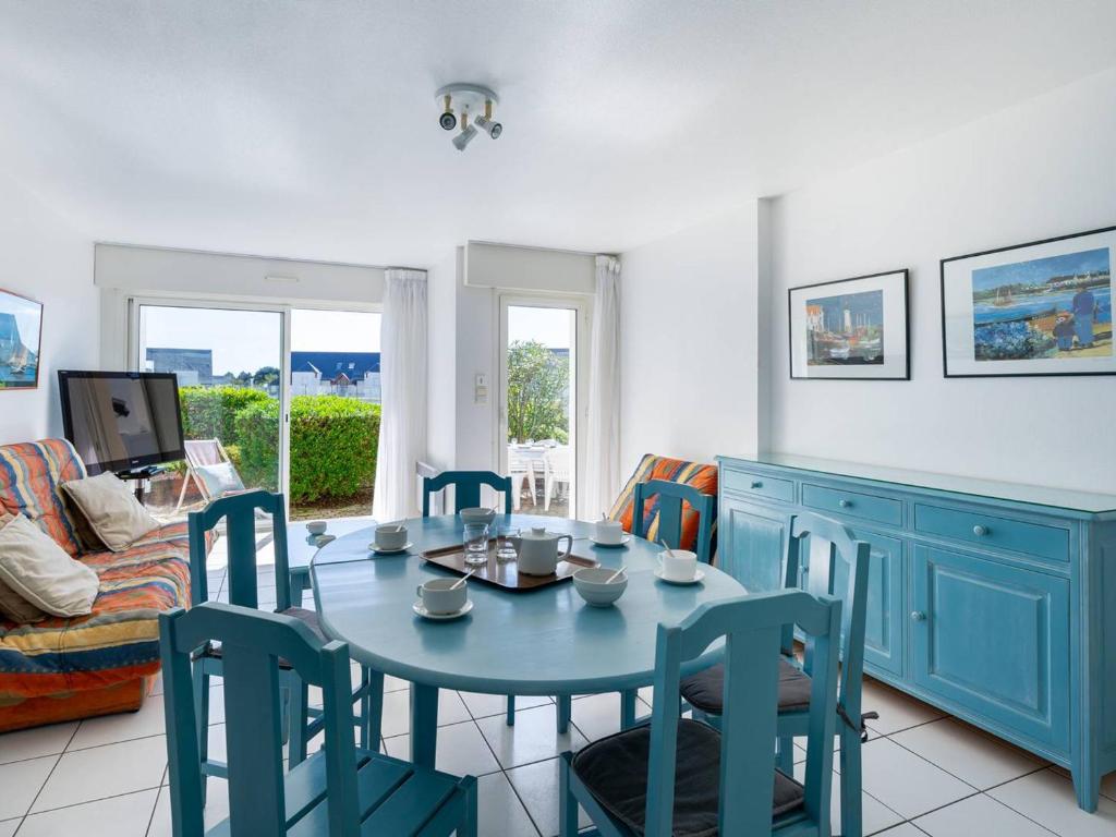 una sala da pranzo con tavolo e sedie blu di Appartement Carnac, 3 pièces, 6 personnes - FR-1-477-102 a Carnac