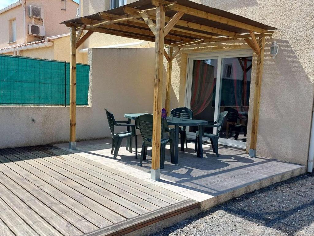une terrasse en bois avec une table et des chaises dessus dans l'établissement Maison climatisée en duplex, 2 chambres, terrasse, garage à 250m de la plage - FR-1-326-754, à Marseillan