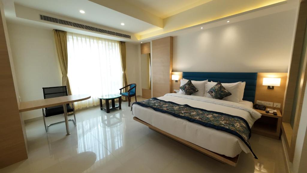 Pokój hotelowy z dużym łóżkiem i biurkiem w obiekcie HOTEL SURYA GRAND w mieście Siliguri