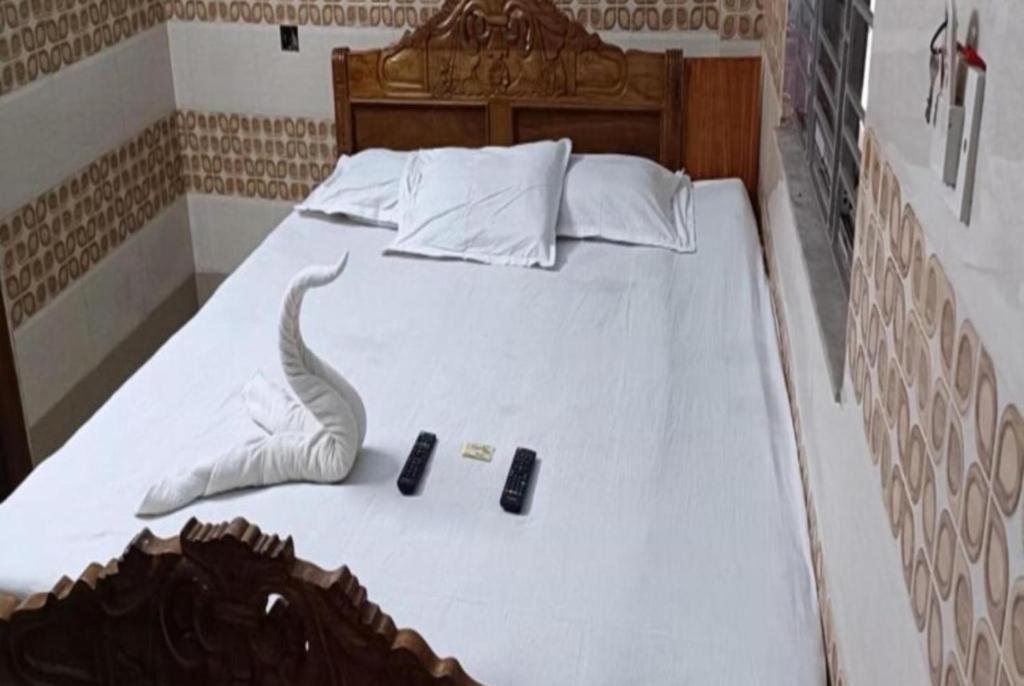 um quarto com uma cama com dois controlos remotos em Hotel Chemistrica Digha Near Old Digha Sea Beach - Couple Friendly em Digha