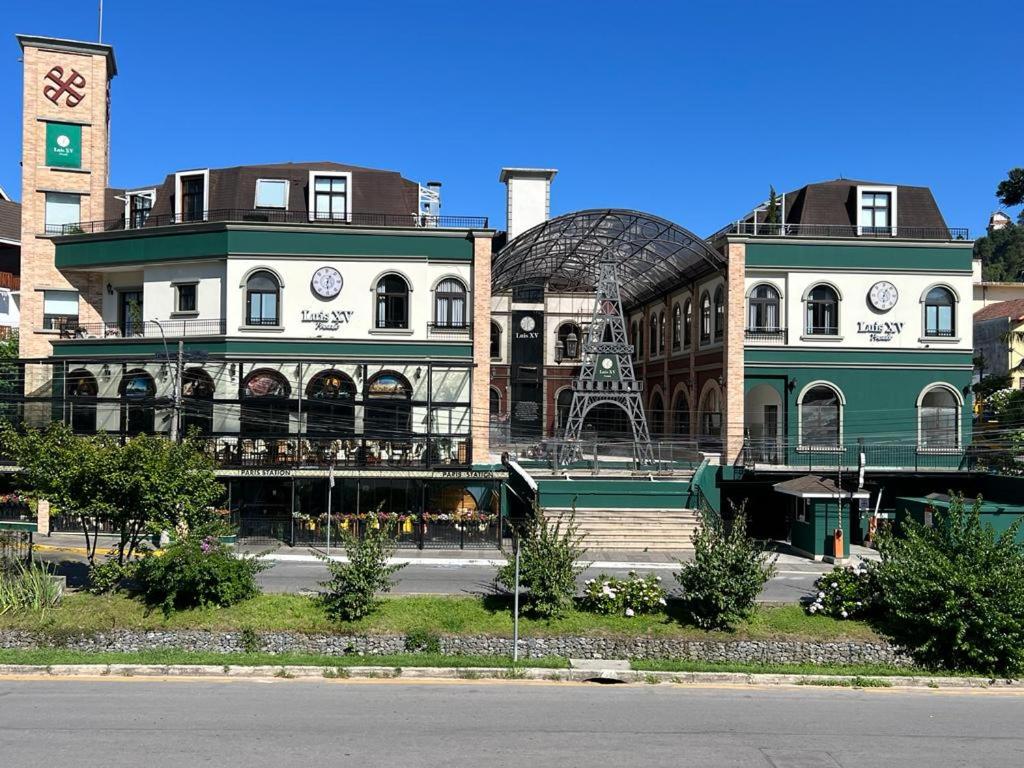 a large building with a clock tower on top of it at Pousada Luis XV in Campos do Jordão