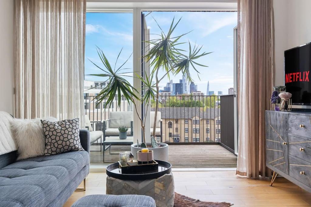 倫敦的住宿－Modern New 1-Bedroom Home Stunning Views，带沙发和大窗户的客厅