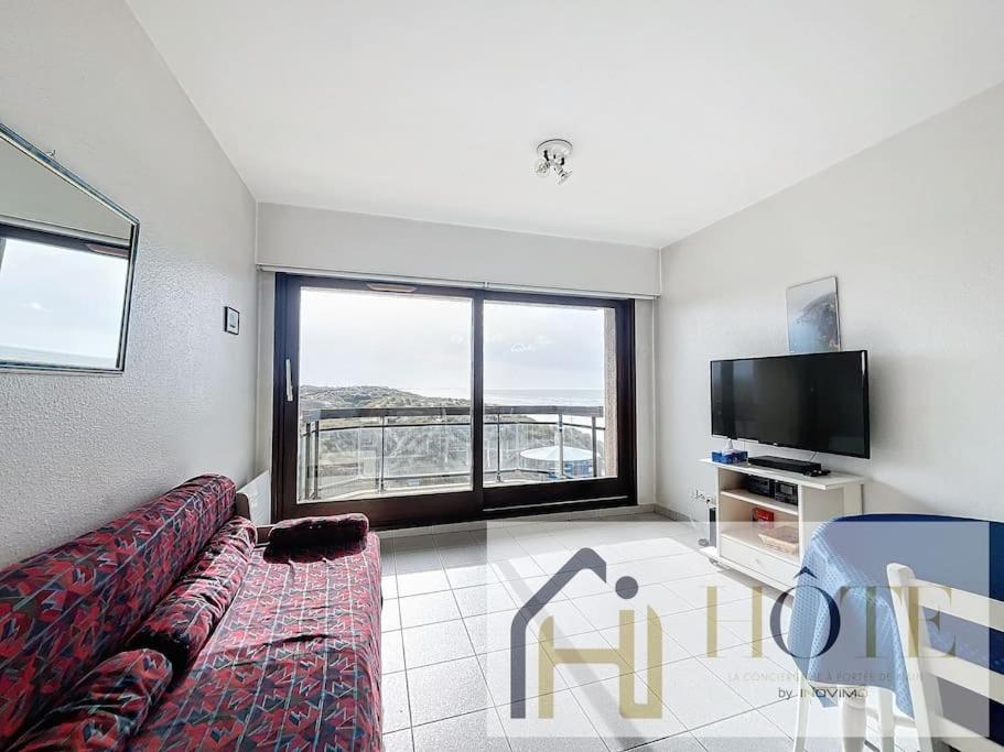 un salon avec un canapé et une télévision à écran plat dans l'établissement Balcon des Dunes - Vue Mer, Confort - Parking, à Bray-Dunes