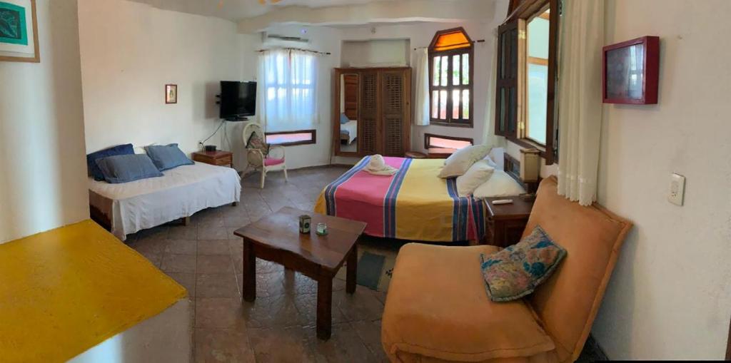 een woonkamer met een bed en een bank bij Hotel Gilda in Coyuca