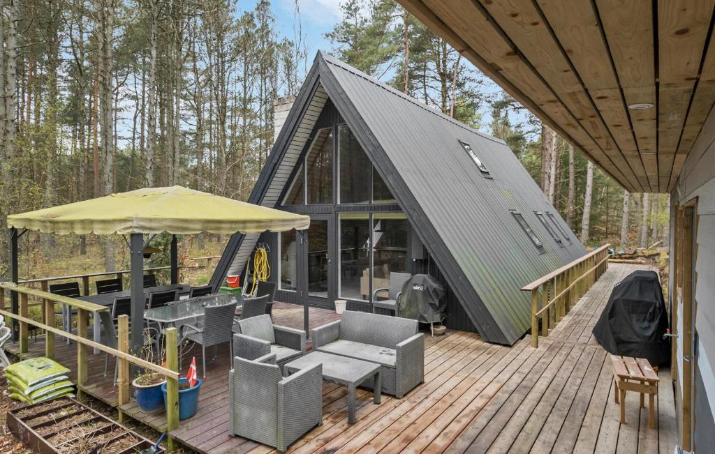 uma pequena casa com um deque e um guarda-chuva em 3 Bedroom Amazing Home In Hadsund em Hadsund
