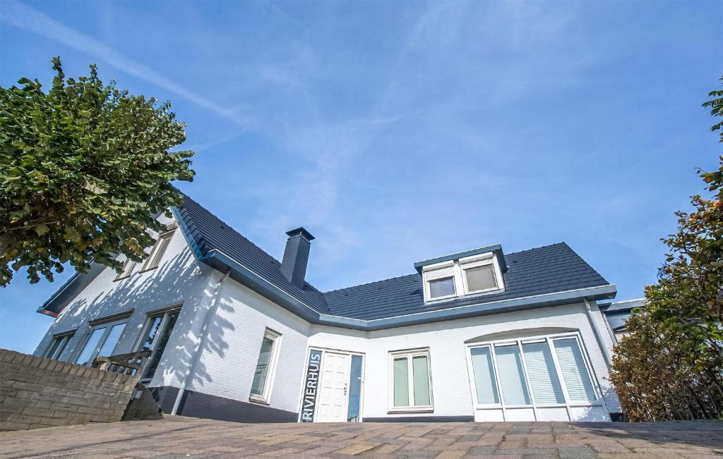 una casa blanca con techo negro en Het Rivierhuis en Maurik