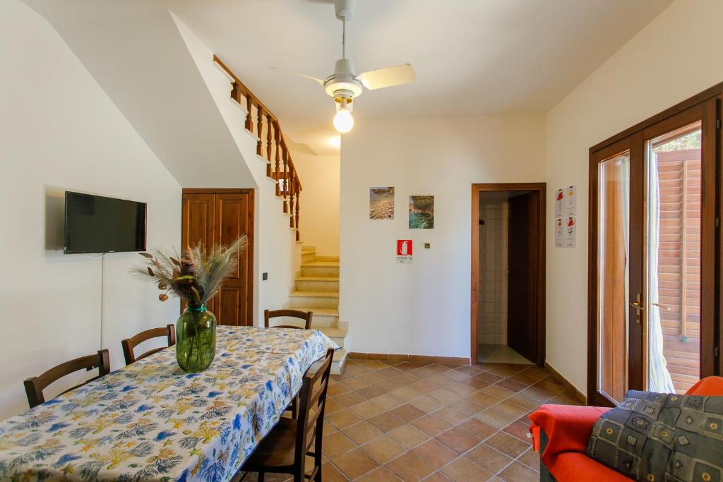a dining room with a table with a vase on it at SanVitoTour- Residence Il Baglio in San Vito lo Capo