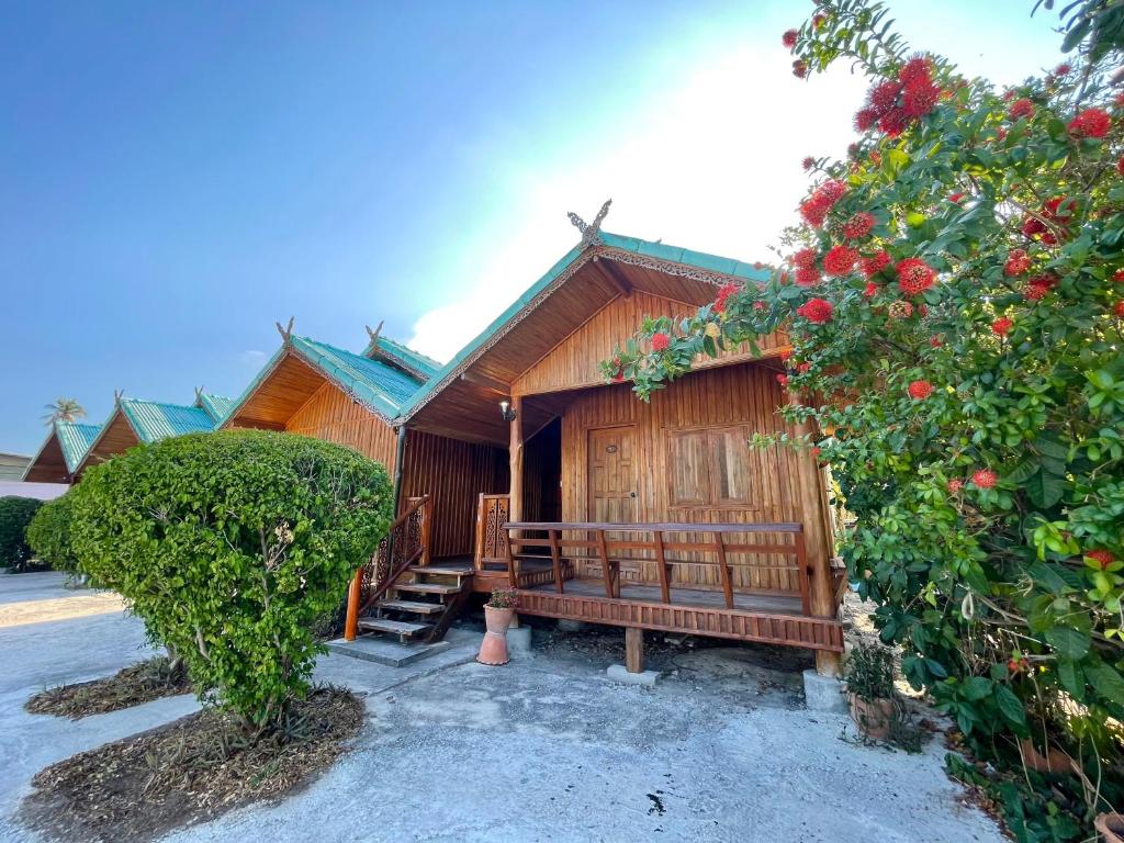 a wooden cabin with a bench in front of it at จันทวี รีสอร์ท in Changwat Prachuap Khiri Khan