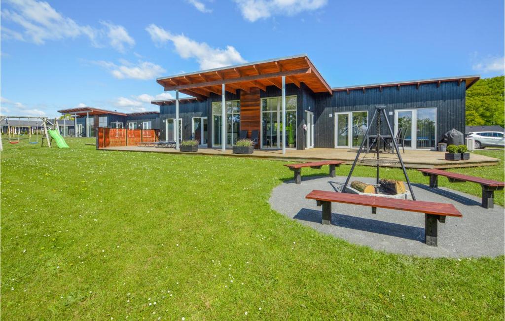 a house with a playground in front of it at Four-Bedroom Holiday Home Haderslev With A Room Hot Tub 09 in Knud