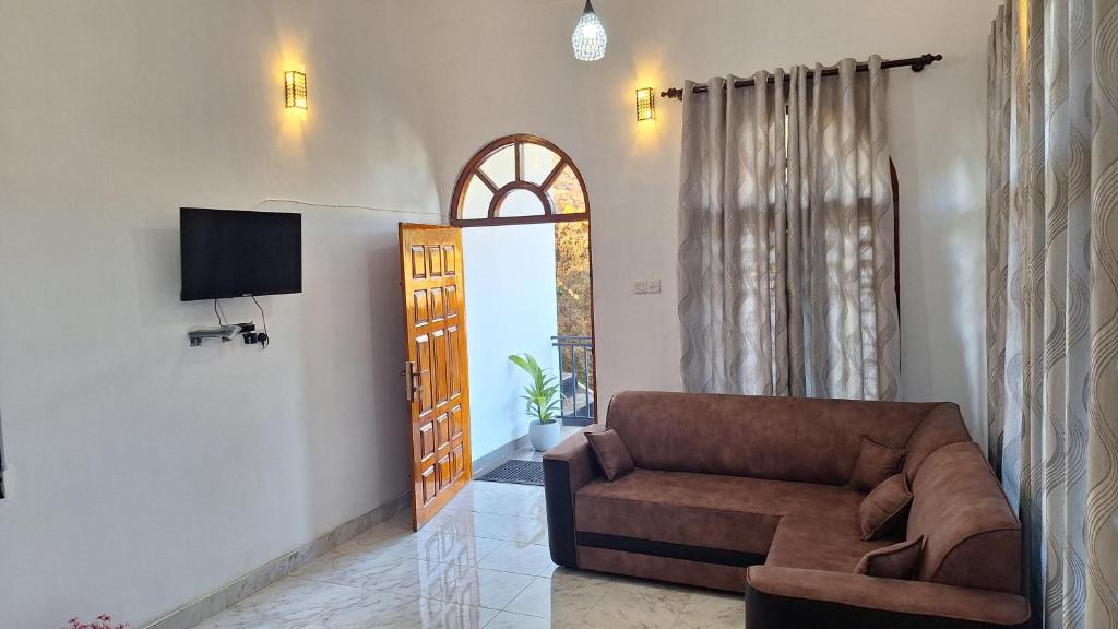 uma sala de estar com um sofá e uma televisão em The Leisure Homestay Ella Bandarawela em Bandarawela