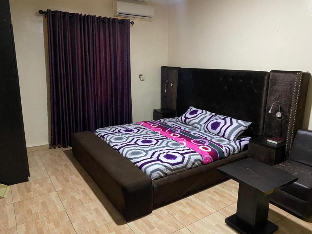拉各斯的住宿－Favour Place，一间卧室配有一张床、一张沙发和一张桌子