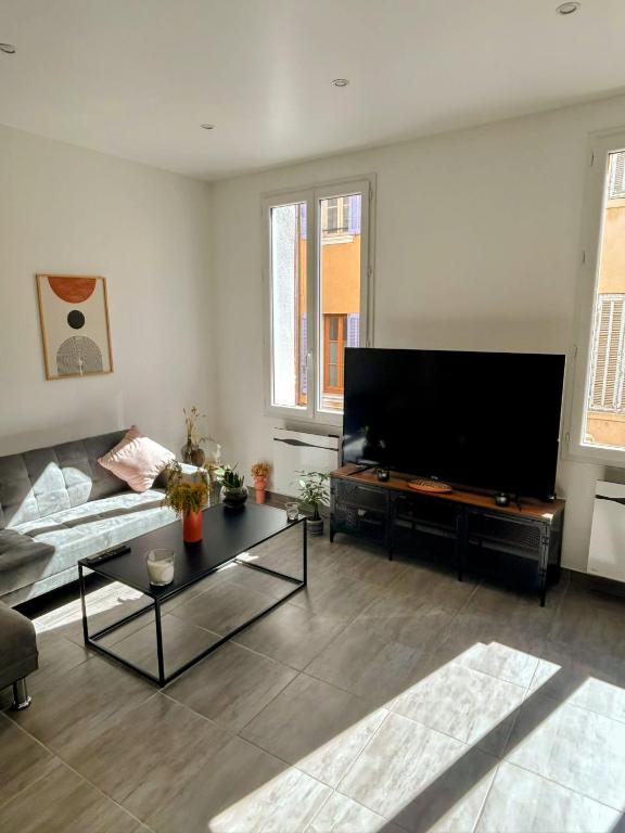 un salon avec un canapé et une télévision à écran plat dans l'établissement Spacious Apartment La Ciotat Old Town, à La Ciotat