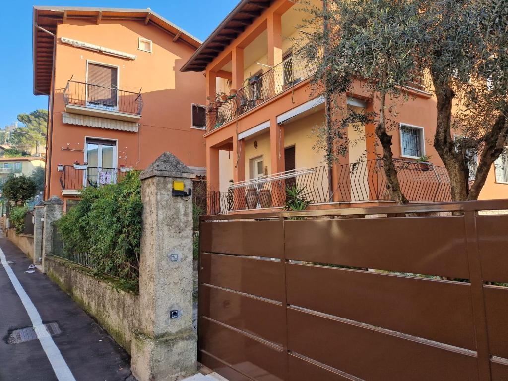 een gebouw met een bruin hek naast een straat bij Casa rosario e annamaria in Torri del Benaco