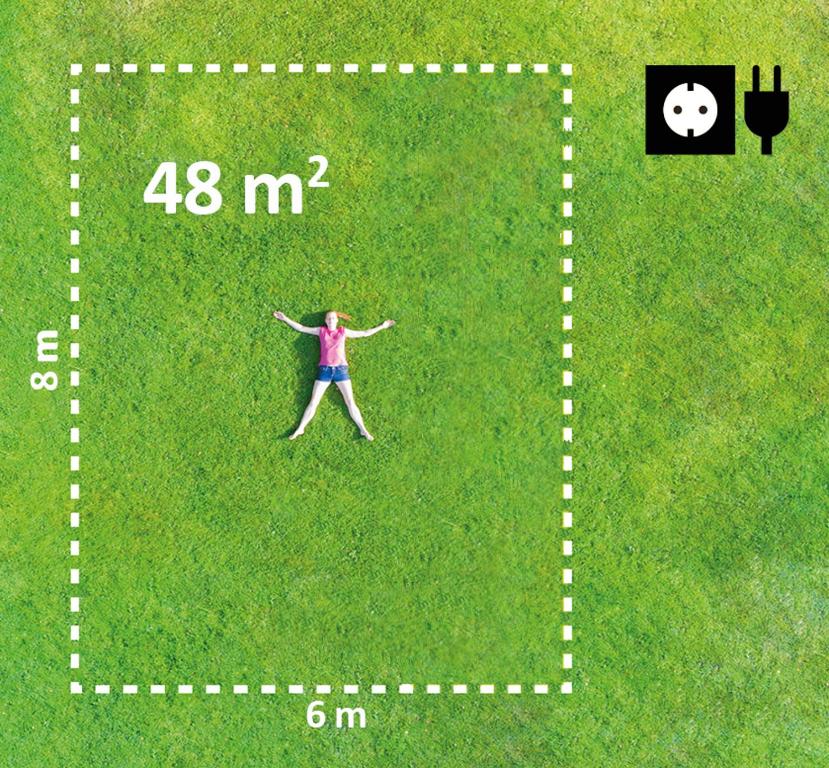 Una mujer de pie en la hierba con los brazos abiertos en Schitterhof CAMPING WEISS, en Spielberg