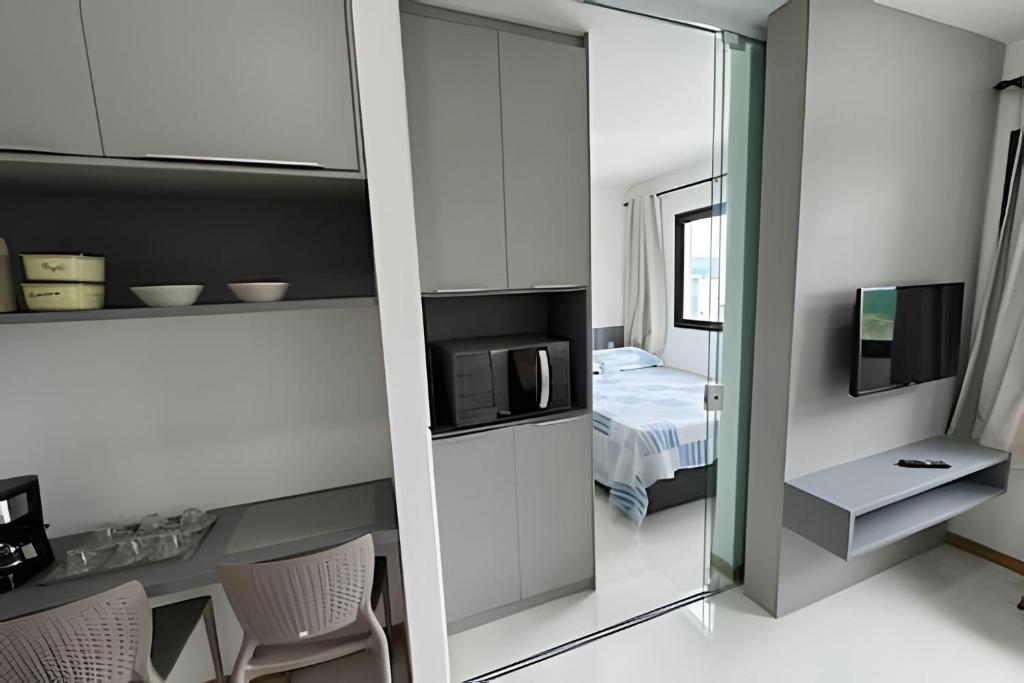 a room with a mirror and a bedroom with a bed at Apt equipado com estacionamento in Salvador