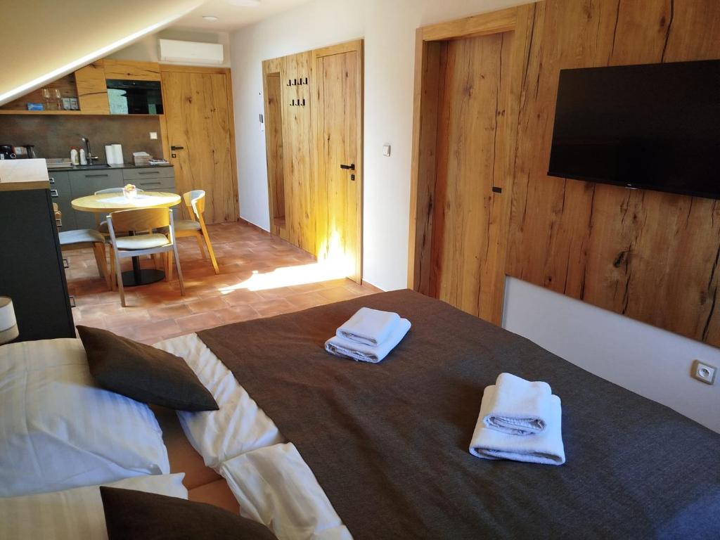 1 dormitorio con 1 cama con toallas en Sklep Víno Strýček en Velké Bílovice