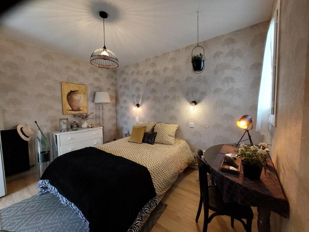 - une chambre avec un lit et une table dans l'établissement La terrasse de Roxane, à Bergerac