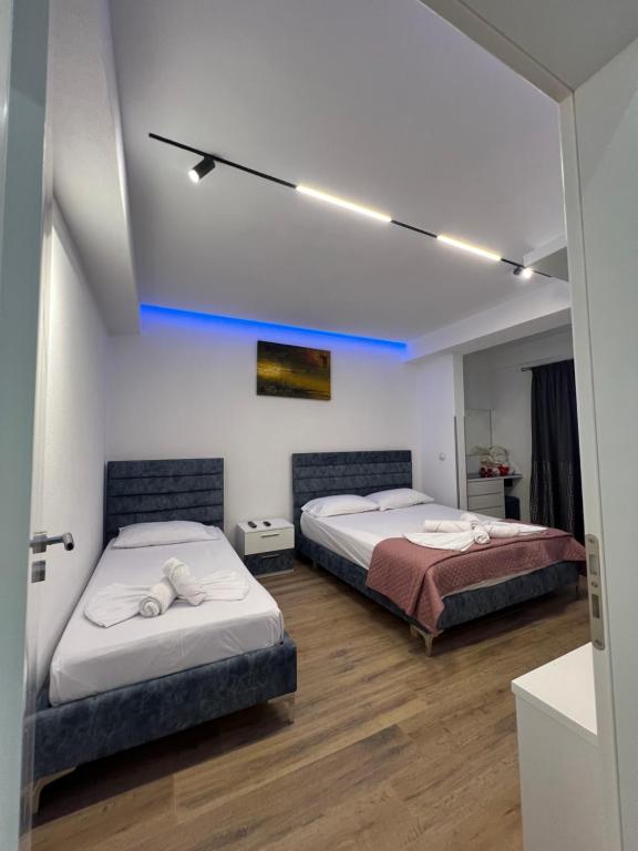 1 Schlafzimmer mit 2 Betten und blauem Licht in der Unterkunft Lovely One-Bedroom Apartment with BBQ-grill! in Sarandë