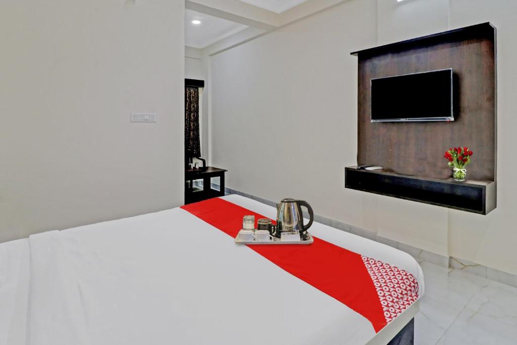 een witte kamer met een bed en een televisie bij OYO Nra Residency Near Rajarajeshwari Nagar Metro Station in Bangalore