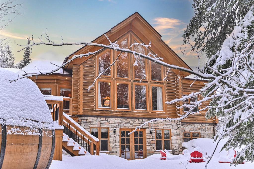 a log home in the snow with a barrel at Fiddler Lake Resort Chalet 53 Cerf in Mille-Isles